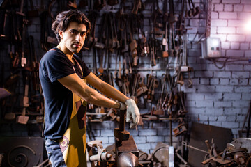 Fototapeta na wymiar italian brunette man blacksmith working in the workshop