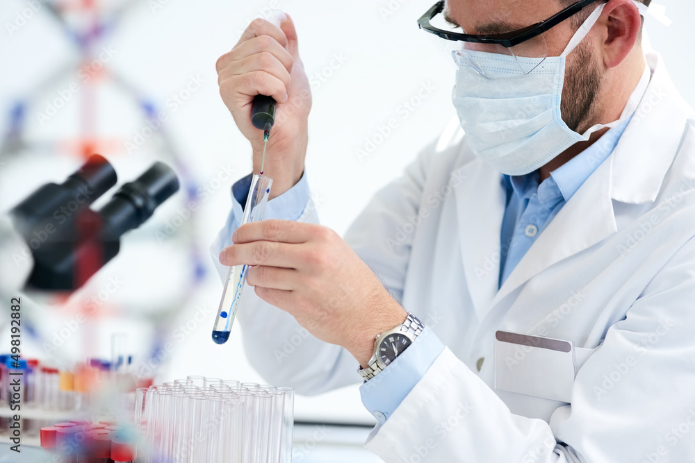 Poster Repeating experiments until he finds the results he needs. Cropped shot of a male scientist conducting an experiment in a lab.