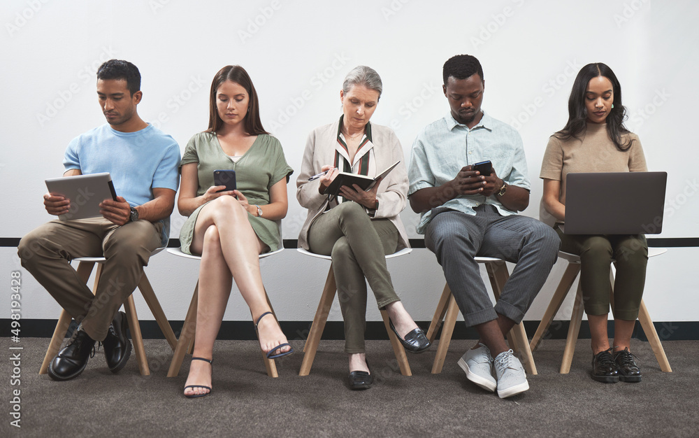 Poster staying focused as they each prepare for something big. shot of a group of businesspeople using digi