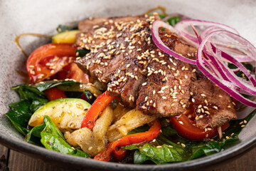 Closeup on vegetables salad with roast meat and sesame seeds