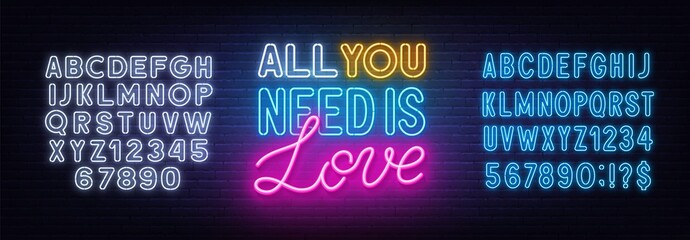 All you need is love neon lettering on brick wall background.