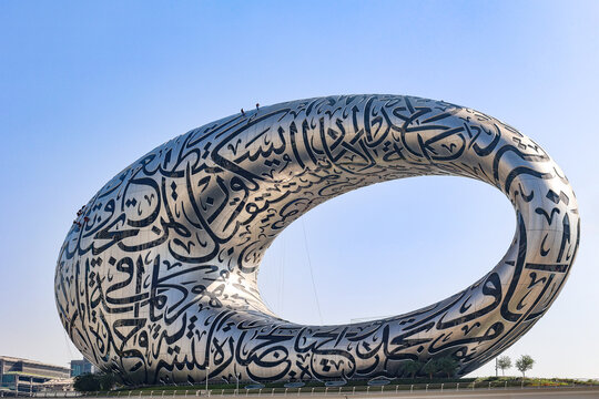 UAE, Dubai - November 27, 2021: People wash windows at Museum of Future. Climbers hang on ropes. Modern futuristic Museum built according designed by architect Shaun Killa. High quality photo