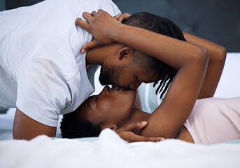 Soulmates say it without words. Shot of a young couple being intimate in bed at home.