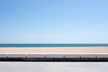 Fotografía muy sencilla y minimalista de playa, paseo marítimo, banco, arena y mar