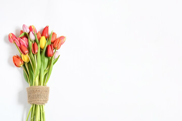 Top view colorful fresh mix tulips flower bunch in bag on white background with space for text....