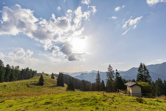 Germany, Bavaria, Bad Wiessee, Summer sun shining over Bavarian Prealps with small chapel in foreground