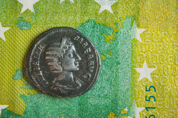 old roman coin lies on euro banknote close up