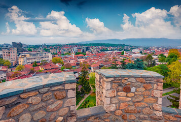 Wonderful summer cityscape of Skopje - capital of North Macedonia, Europe. Stone wall of Skopje fortress - remains of a 6th-century hilltop stone fortress. Traveling concept background. - obrazy, fototapety, plakaty