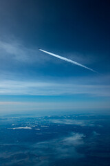 Airliner mit Kondensstreifen vor blauem Himmel