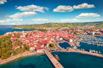 Fototapeta na wymiar Captivating summer cityscape of Izola town, Slovenia. Superb morning seascape of Adriatic sea. View from flying drone of old sea port. Сharm of the ancient cities of Europe. 