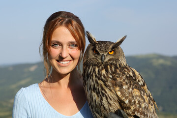Happy falconer with an eagle owl looking at camera