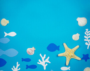 Obraz na płótnie Canvas Starfish with seashells and fish made of paper on a blue background. Recreation Concept