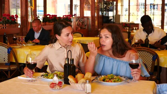 Girl complains to her friend at a table in a restaurant. High quality 4k footage