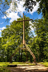 Symbolic cross below observation tower on top of Wiezyca hill near Szymbark town in Pomerania of Kashubian region of Poland - obrazy, fototapety, plakaty