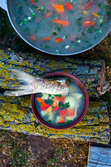 Fish soup prepared over an open fire. Cooking fish soup over an open fire in a kettle. Cooking in hiking tourism and fishing