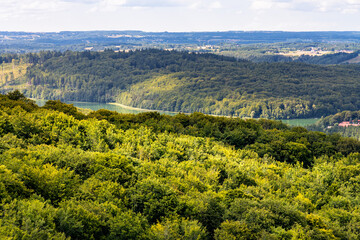 Panorama of summer forest hills and lake valleys of Kashubian landscape park seen from Wiezyca hill observation tower near Szymbark town in Pomerania region of Poland - obrazy, fototapety, plakaty