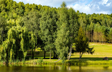 Panoramic view of Jezioro Wegleszynskie lake with wooded shores and surrounding hills in Ostrzyce village in Kashubia near Szymbark town in Pomerania region of Poland