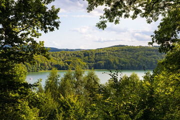 Panoramic view of Jezioro Ostrzyckie lake with shores of forest seen from Jastrzebia Gora Hawk Mountain in Ostrzyce village of Kashubia in Pomerania region of Poland - obrazy, fototapety, plakaty