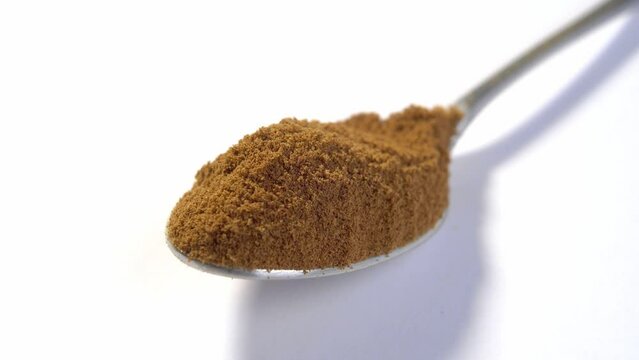 A full teaspoon of dry instant chicory root powder on a white background. Caffeine free concept. Replacing coffee to fight addiction. Macro. Rotation