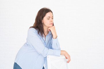 Portrait of a pensive woman with closed eyes on white background. Posing in the studio concept