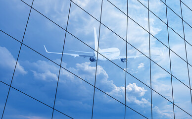 Airplane reflected in skyscraper windows