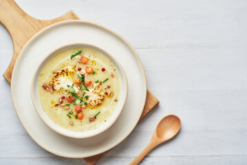 Vegan cauliflower soup on white background. Healthy vegan cauliflower soup served in bowl on white...