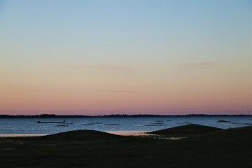 Scenery of evening time after sunset on blue lake and gold sky