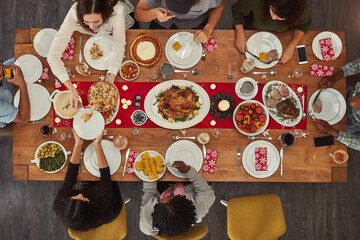 Food makes coming together easy. Shot of a group of people sitting together at a dining table ready...