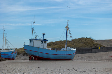 An old fisher boat at a beach not far away from Aalborg in Denmark at a sunny but cold day in spring.