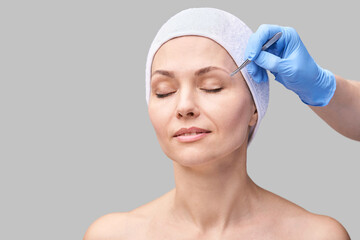 Beautician skin care. Face tweezers. Facial treatment. Woman dermatology. Salon routine. Applying...