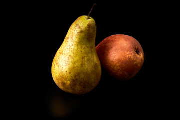 Red and green ripe pears on a black background. Healthy food. Vegan and vegetarian food