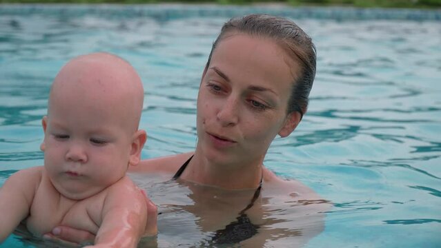 Mom swims with a child in the pool