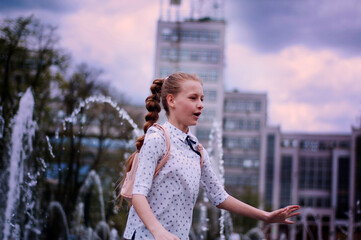Girl on the background of a fountain and a city building