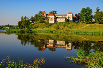 Picturesque summer scenery with medieval Svirzh Castle reflected in lake water. Lviv region, Ukraine