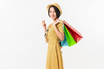 Young smiling asian woman holding multicolour shopping bags and looking on white background.
