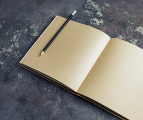 Blank vintage sketchbook and pencil on concrete background. Responsive design template.