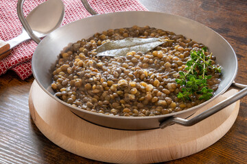 lentils cooked in a dish with bay leaf on a table