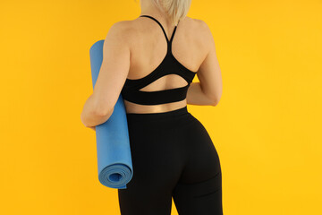 Fototapeta premium Concept of healthy lifestyle with sporty woman on yellow background