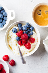 Rice pudding with berries and butter. Porridge bowl with raspberries and blueberries.