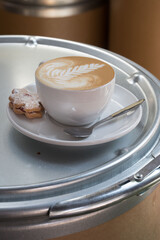 cup of coffee served with a cookie 