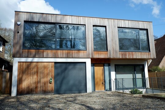 Modern two storey flat roofed house, clad with external cedar wood