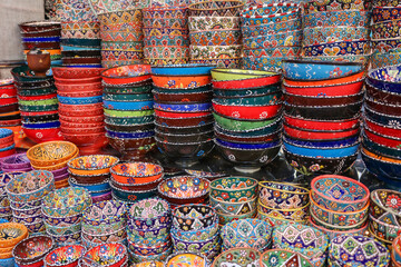 Colorful east ceramic plates and bowls with national pattern in colorful colors. National tableware on Traditional market in Dubai, UAEz. High quality photo