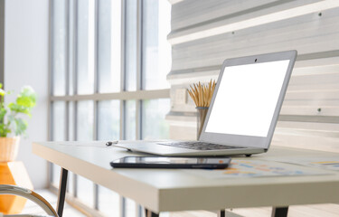 Fototapeta na wymiar Laptop with blank screen on table in modern office