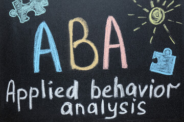 Text ABA Applied behavior analysis and drawings on blackboard - obrazy, fototapety, plakaty