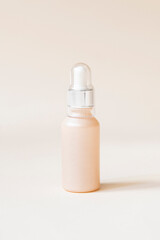 Beige serum container on cream background