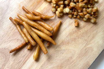 Fresh raw Fingerroot culinary herb medicine Boesenbergia rotunda, Chinese keys, or lesser galangal or Chinese ginger on bamboo wooden chopping board background