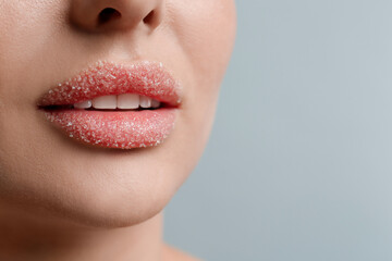 Fototapeta premium Closeup view of woman with lips covered in sugar on light grey background. Space for text