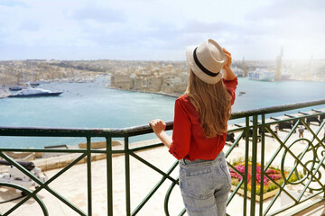 Tourism in Malta. Back view of beautiful girl enjoying view of Three Cities from Upper Barrakka...