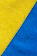 Colors of the Ukrainian flag. Soft knit sweaters in yellow and blue. Support for Ukraine. Background and texture of warm soft cozy knitted sweater. High quality photo