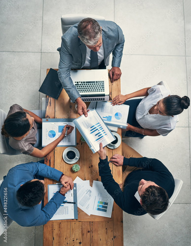 Sticker Success is on the top of their agenda. High angle shot of a group of businesspeople having a meeting in an office.